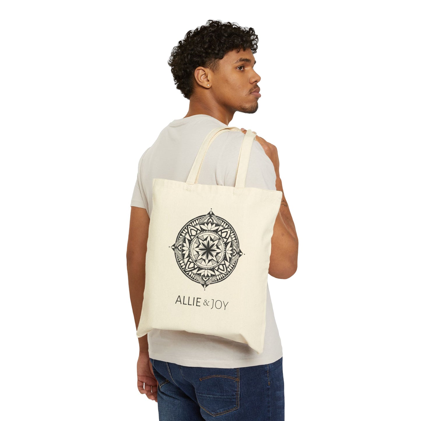 Man carrying a tote bag with mandala pattern and Allie & Joy logo below on a white background